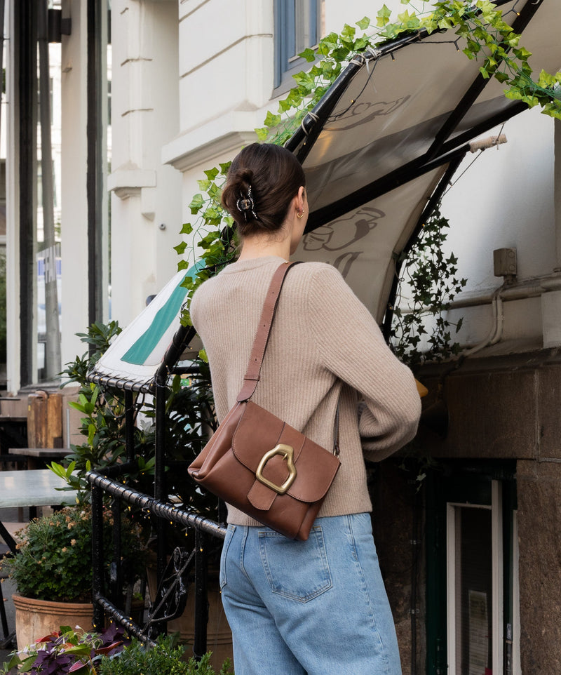 Cala Jade brown shoulder bag with buckle on a model